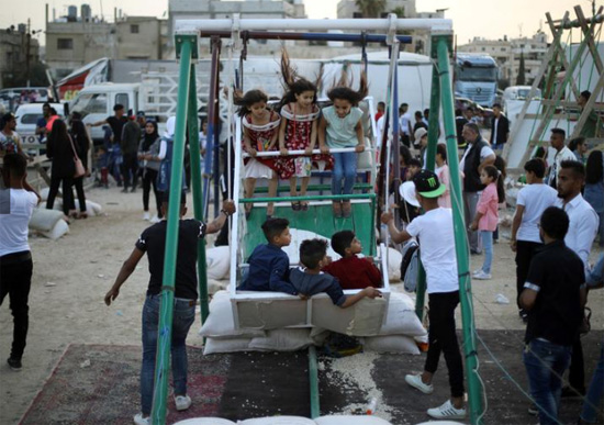 أطفال-يلعبون-على-أرجوحة-،-في-أول-أيام-عيد-الفطر-في-عمان-،-الأردن-،-5-يونيو.-رويترز--محمد-حامد