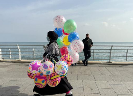 امرأة-تحمل-بالونات-للبيع-وهي-تمشي-على-طول-كورنيش-البحر-،-خلال-عطلة-عيد-الفطر-في-بيروت-،-...-03-مايو-2022-،-الساعة-0159-صباحًا-بتوقيت-شرق-الولايات-المتحد