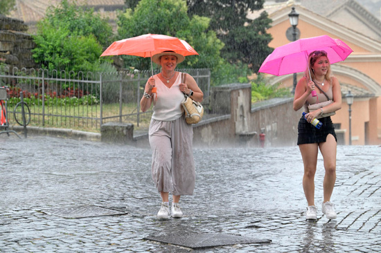 سائحون يمشون تحت المطر فى روما