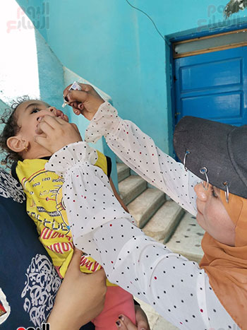 طفلة-خلال-تلقى-التطعيم-أمام-منزلها