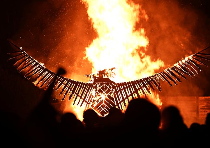 المحتفلين يهتفون بينما يتم حرق طائر الفينيق الخشبي في مهرجان جلاستونبري في بريطانيا