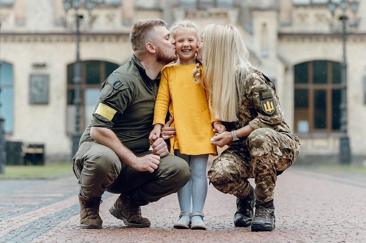 جندي وجندية يقبلان طفلتهما
