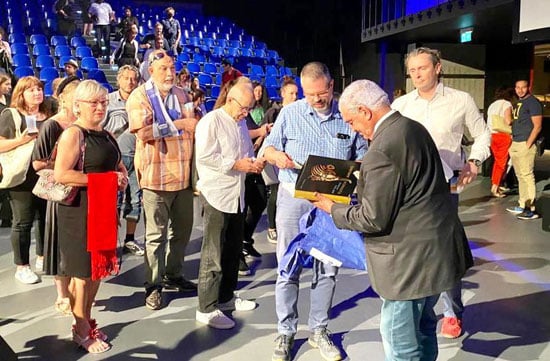 زاهي-حواس-يعرض-كتبًا-على-المشاركين-في-الندوة زاهي-حواس-يعرض-كتبًا-على-المشاركين-في-الندوة