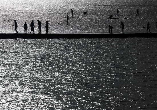 أشخاص يسيرون على حافة حوض سباحة في البحر في مارغيت ، بريطانيا