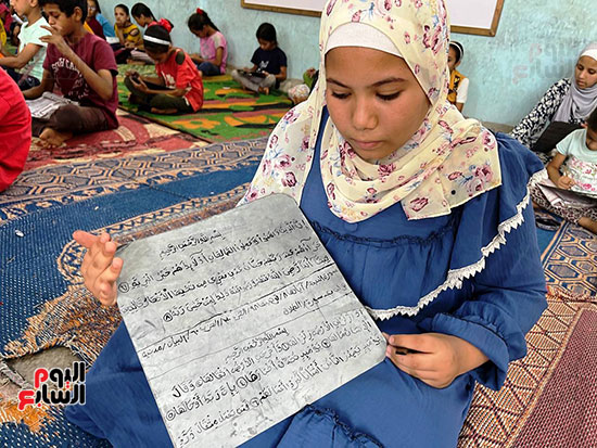طفلة-تكتب-القرآن-على-اللوح-الصفيح
