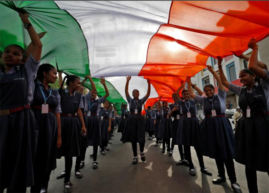 طلاب يحملون علمًا وطنيًا هنديًا عملاقًا خلال مسيرة