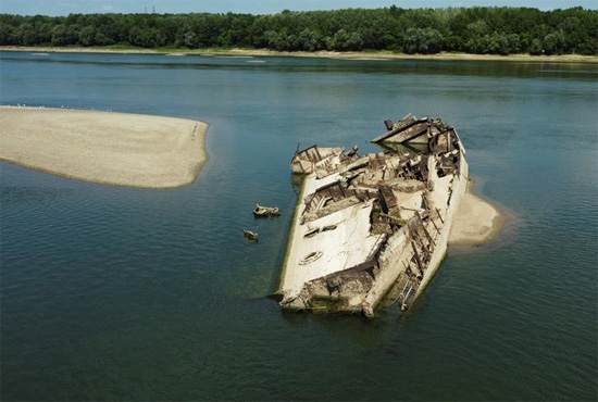 السفن المتناثرة عبر قاع النهر تفتخر بالأبراج والجسور القيادية والصواري المكسورة