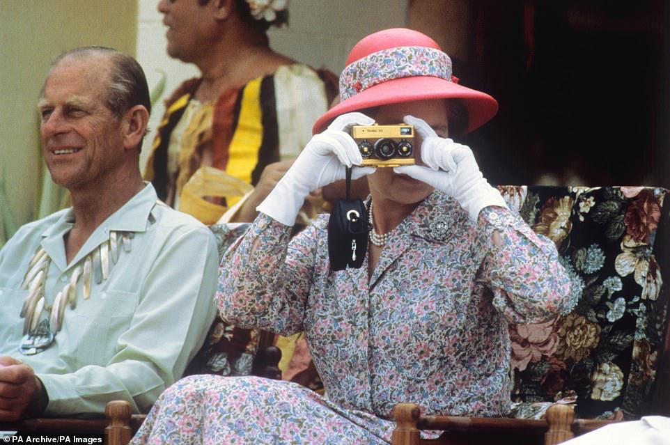 تلتقط الملكة صورًا فوتوغرافية بكاميرا Rollei الذهبية الخاصة بها أثناء زيارتها لجزر بحر الجنوب في توفالو في 26 أكتوبر 1982.