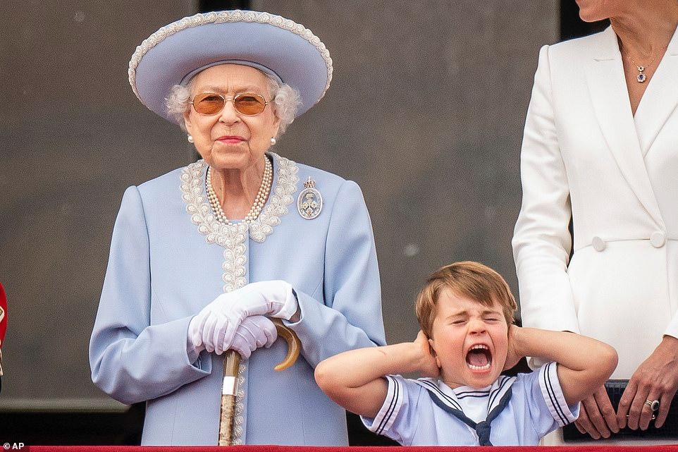 الملكة إليزابيث الثانية تقف بينما الأمير لويس يغطي أذنيه على شرفة قصر باكنغهام بعد حفل Trooping the Colour في Horse Guards Parade خلال احتفالات اليوبيل ا