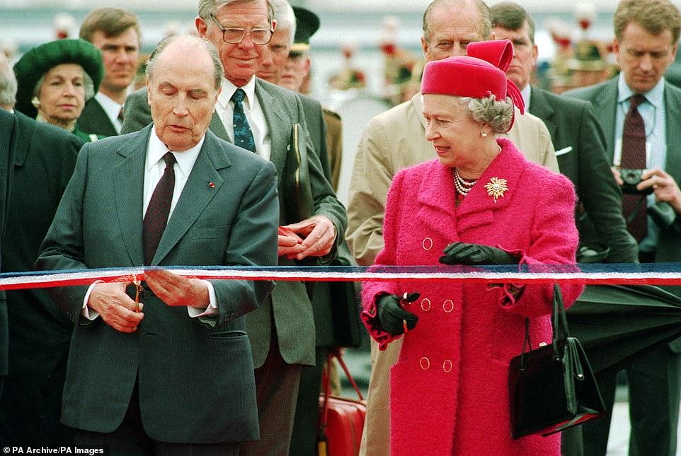 الرئيس الفرنسي فرانسوا ميتران والملكة إليزابيث الثانية يستعدان لقص الشريط في المحطة الجديدة لنفق القناة في كوكيل  فرنسا  في 6 مايو 1994