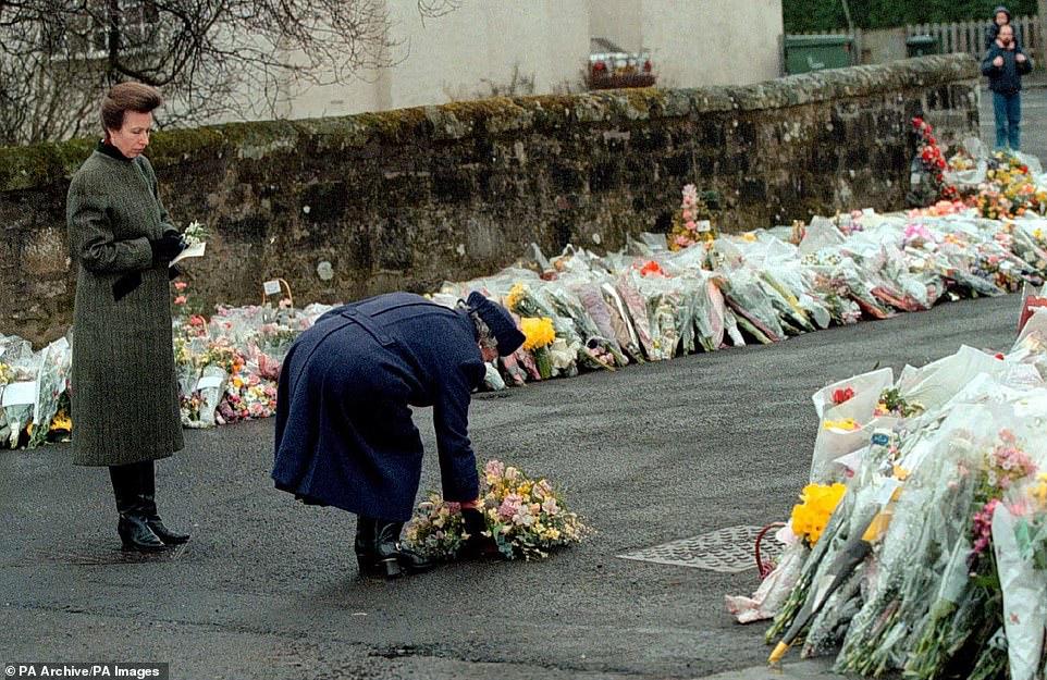 الملكة إليزابيث الثانية تضع إكليلًا من الزهور على أبواب مدرسة دانبلين الابتدائية في 17 مارس 1996  بعد واحدة من أعنف حوادث الأسلحة النارية في تاريخ المملك