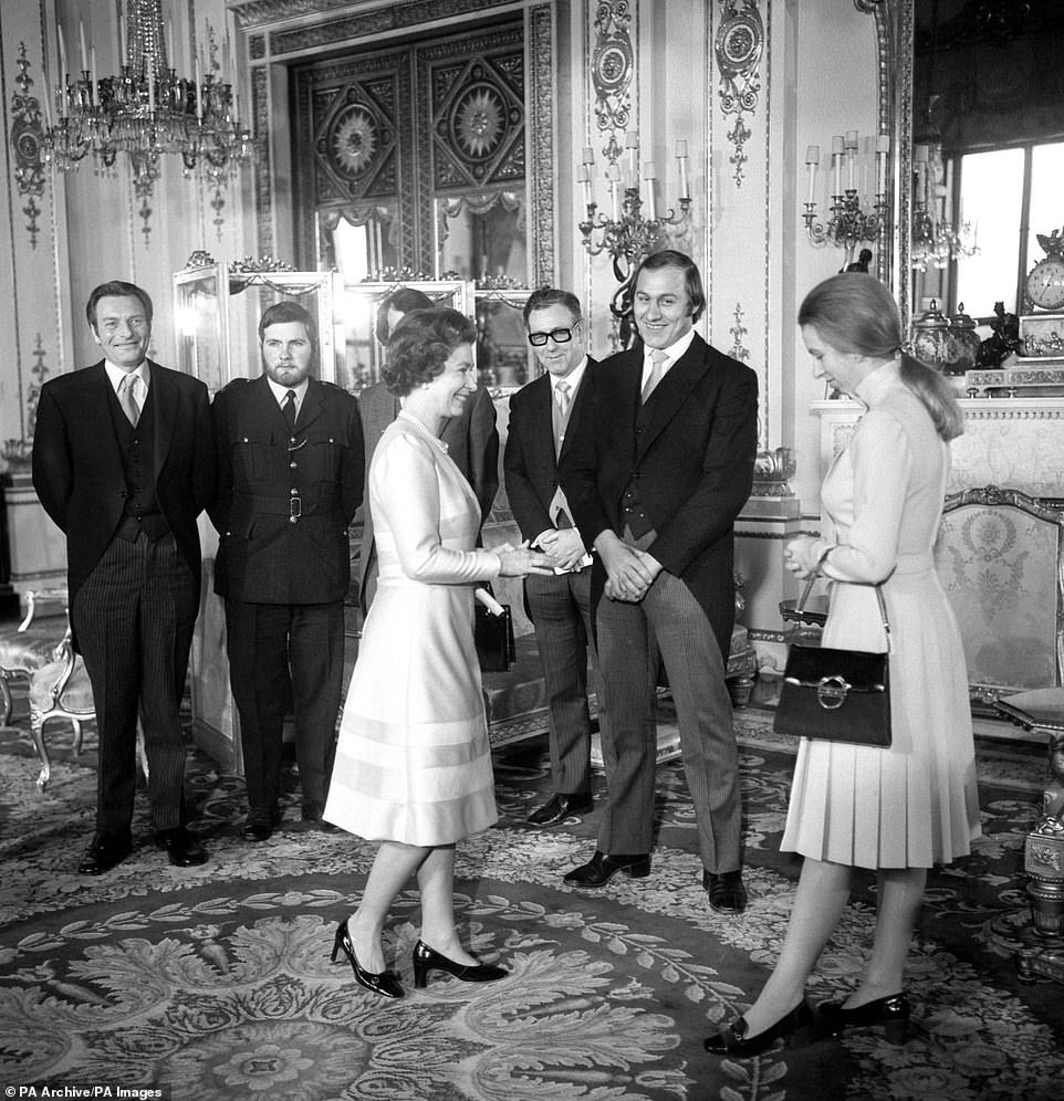الملكة والأميرة آن في قصر باكنغهام في 26 نوفمبر 1974 ، مع تكريم بعض الأبطال بعد مساعدة آن أثناء محاولة خطفها أثناء عودتها إلى القصر على طول بال مول. عندما