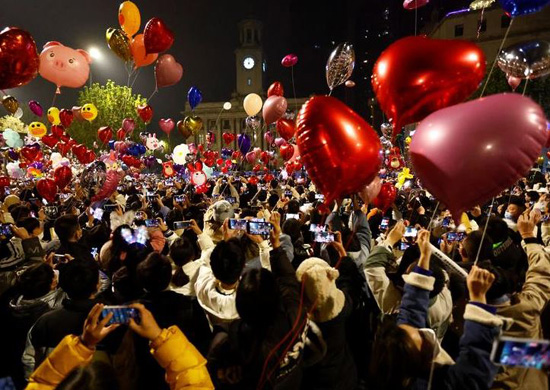 الناس يطلقون البالونات أثناء تجمعهم للاحتفال بليلة رأس السنة الجديدة ، وسط تفشي فيروس كورونا COVID ، في ووهان ، مقاطعة هوبي ، الصين. تصوير تينغشو وانغ - رويترز