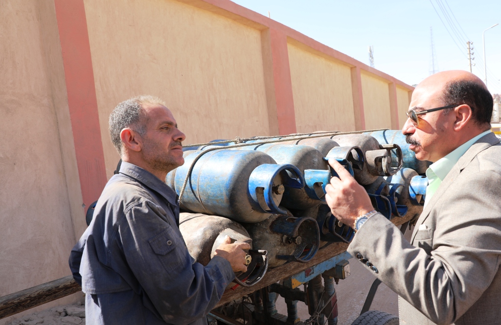 محافظ أسوان مع أحد الباعة المتجولين لاسطوانات البوتاجاز