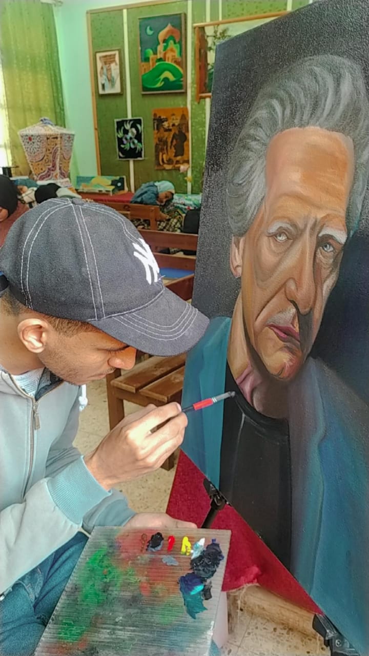 The artist Ahmed El-Araby while painting one of his paintings