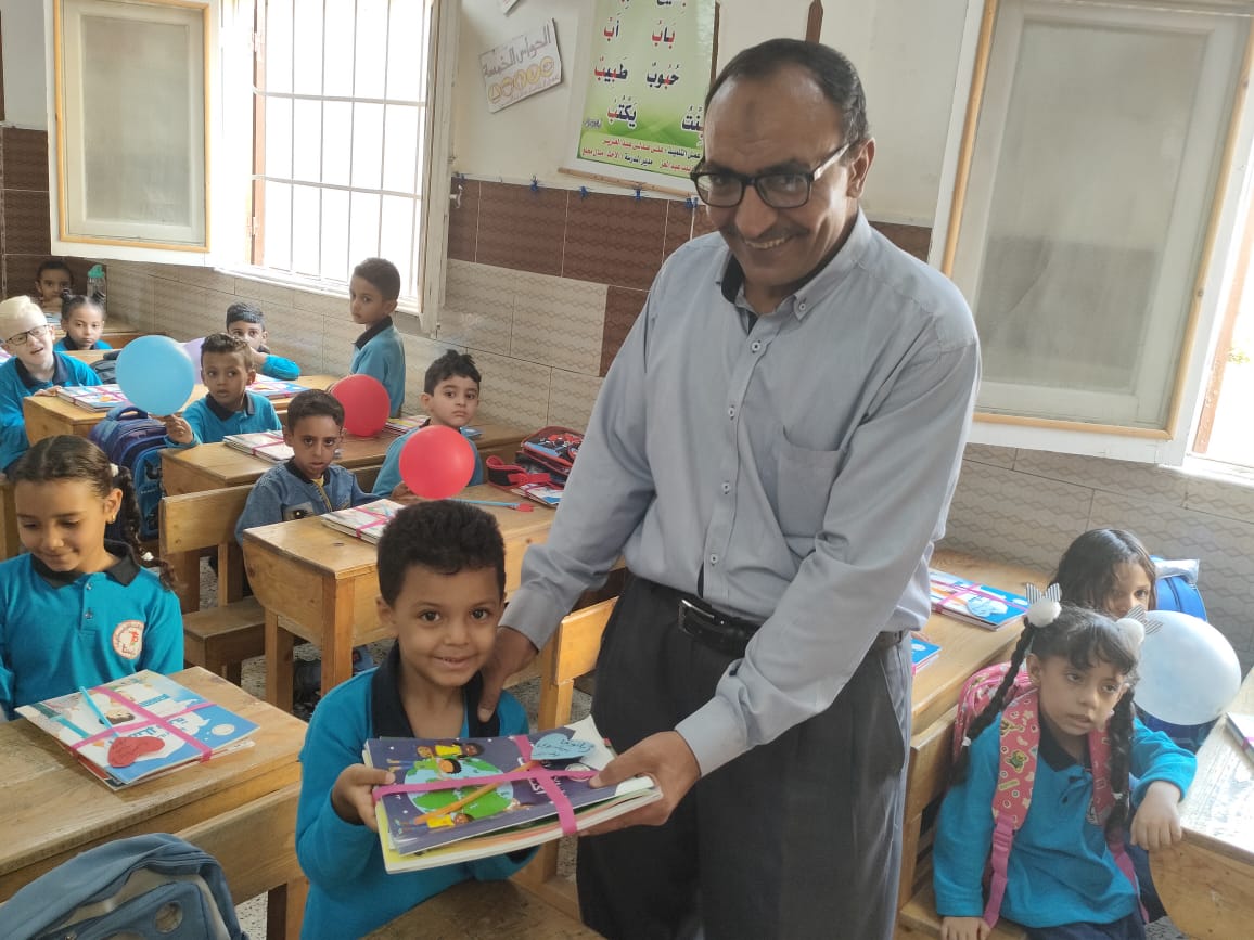 فرحة توزيع الكتب المدرسة على الأطفال بالمدارس