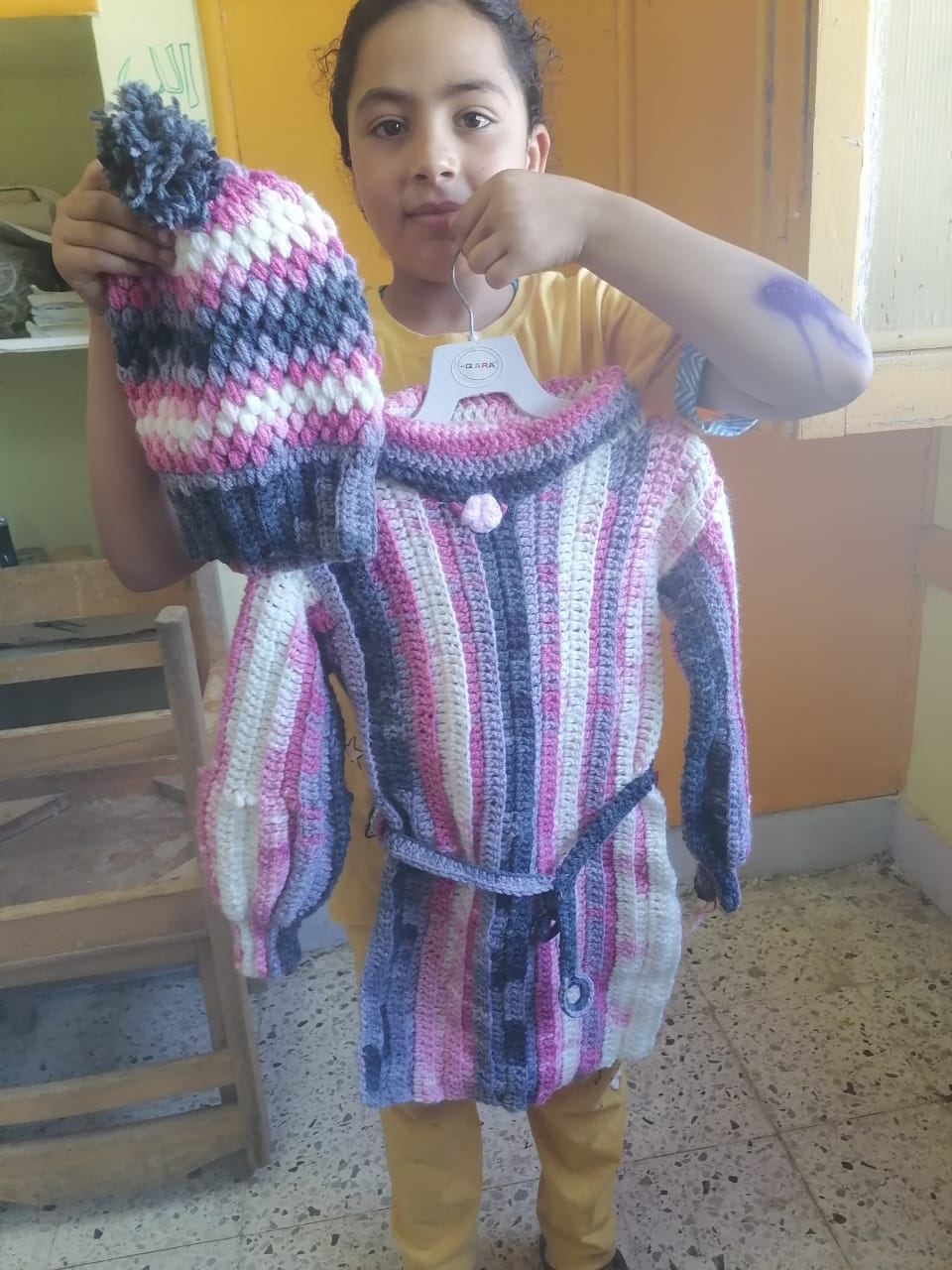 طفلة تمسك بملبس شاركت في تصميمه
