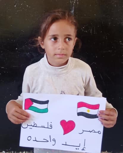 وفتاة أخرى تحمل لافتة لدعم مصر لفلسطين