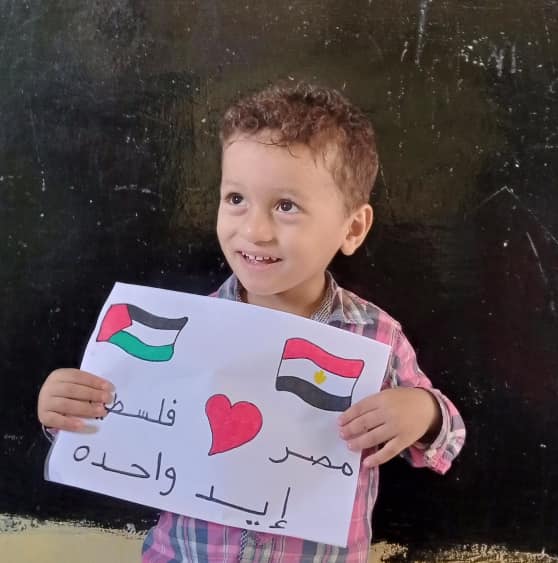 طفل يحمل رسمة تعبر عن دعم مصر لفلسطين