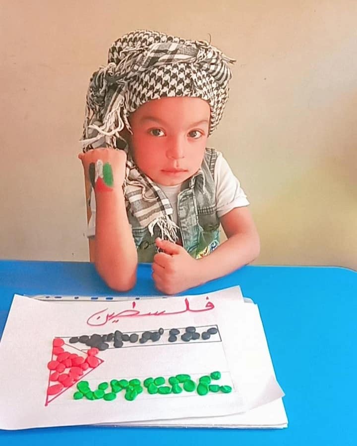 طفل يرسم العلم الفلسطيني