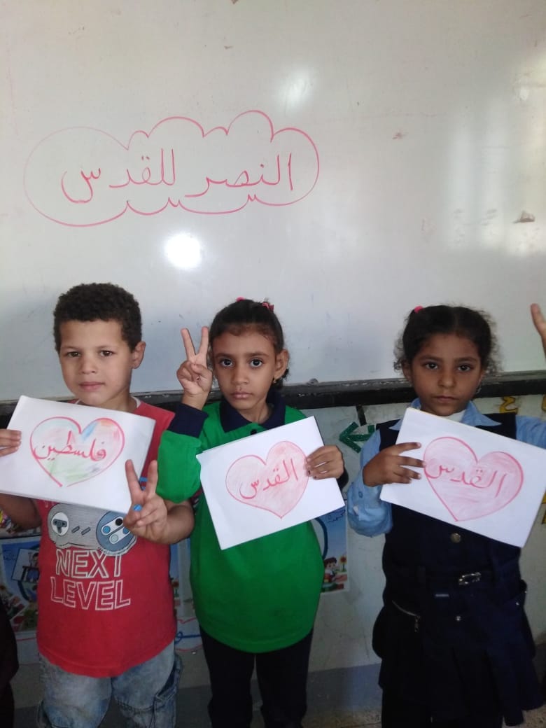 أطفال يرسمون اسمي فلسطين والقدس في قلوبهم