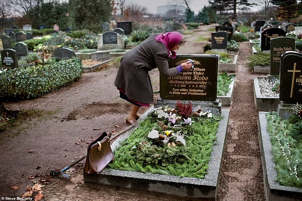 امرأة تنظف شاهد قبر زوجها الراحل في ألمانيا الشرقية عام 1989