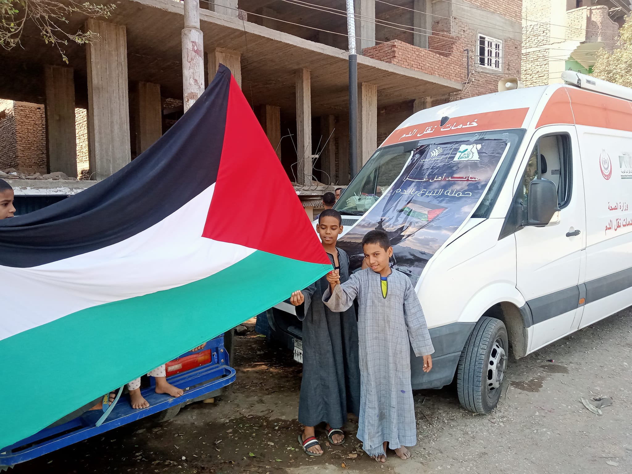 أطفال من الأقصر يرفعون علم فلسطين خلال حملة تبرع بالدم