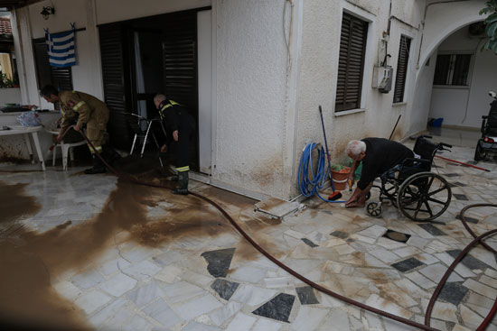 مواطنين يقمون بتنظيف المنازل بعد ان غمرتها المياه نتيجة العاصفة الياس