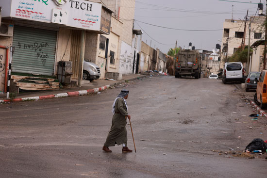 مسن فلسطينى يسير امام الايات العسكرية فى شوارع طولكرم بالضفة الغربية