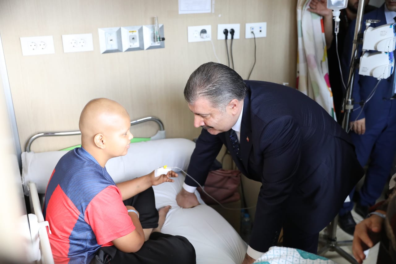 وزير الصحة التركى مع طفل مصاب خلال الزيارة