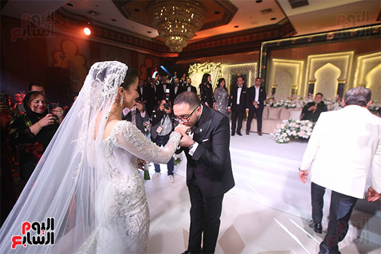 نجل محمد ثروت يقبل يد عروسته فى عقد القران