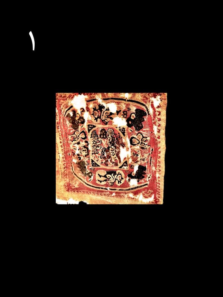 قطعة فريدة من النسيج علي خلفية حمراء تمثل رحلة العائلةالمقدسة إلى مصر