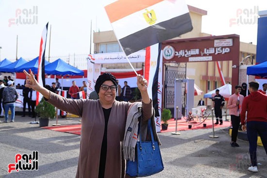 سيدة سعيدة بالانتخابات تحمل علم مصر