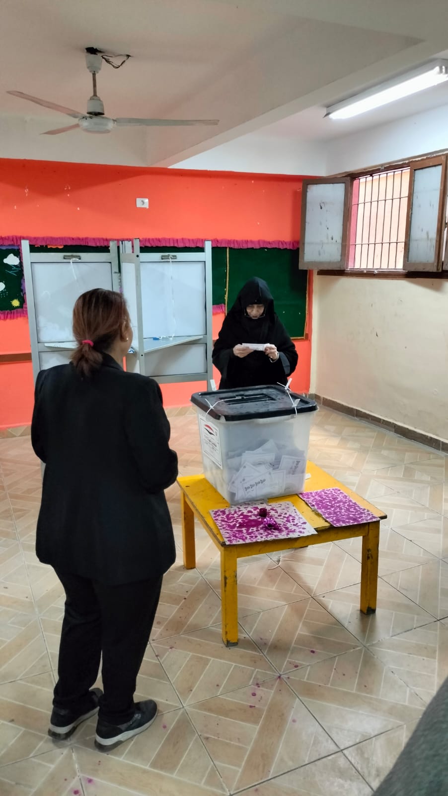راهبة تطلع على ورقة الانتخابات قبل الإدلاء بصوتها في الجمالية