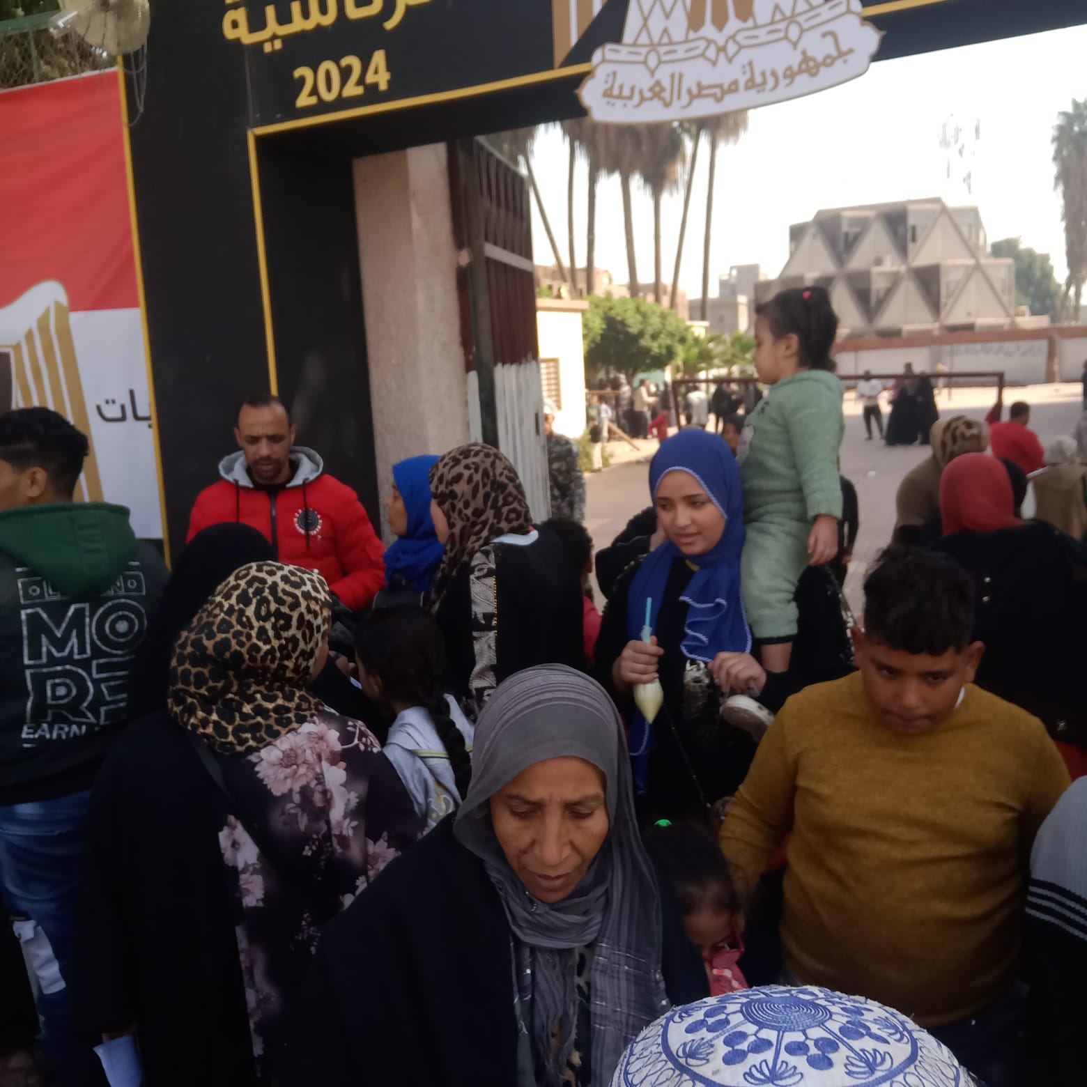 سيدة تحمل ابنتها على كتفها داخل لجنة الانتخابات