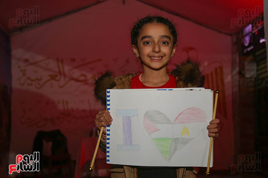 طفلة تشارك أسرتها التصويت بالانتخابات بكراسة رسم ورسمة لعلم مصر وفلسطين (3)