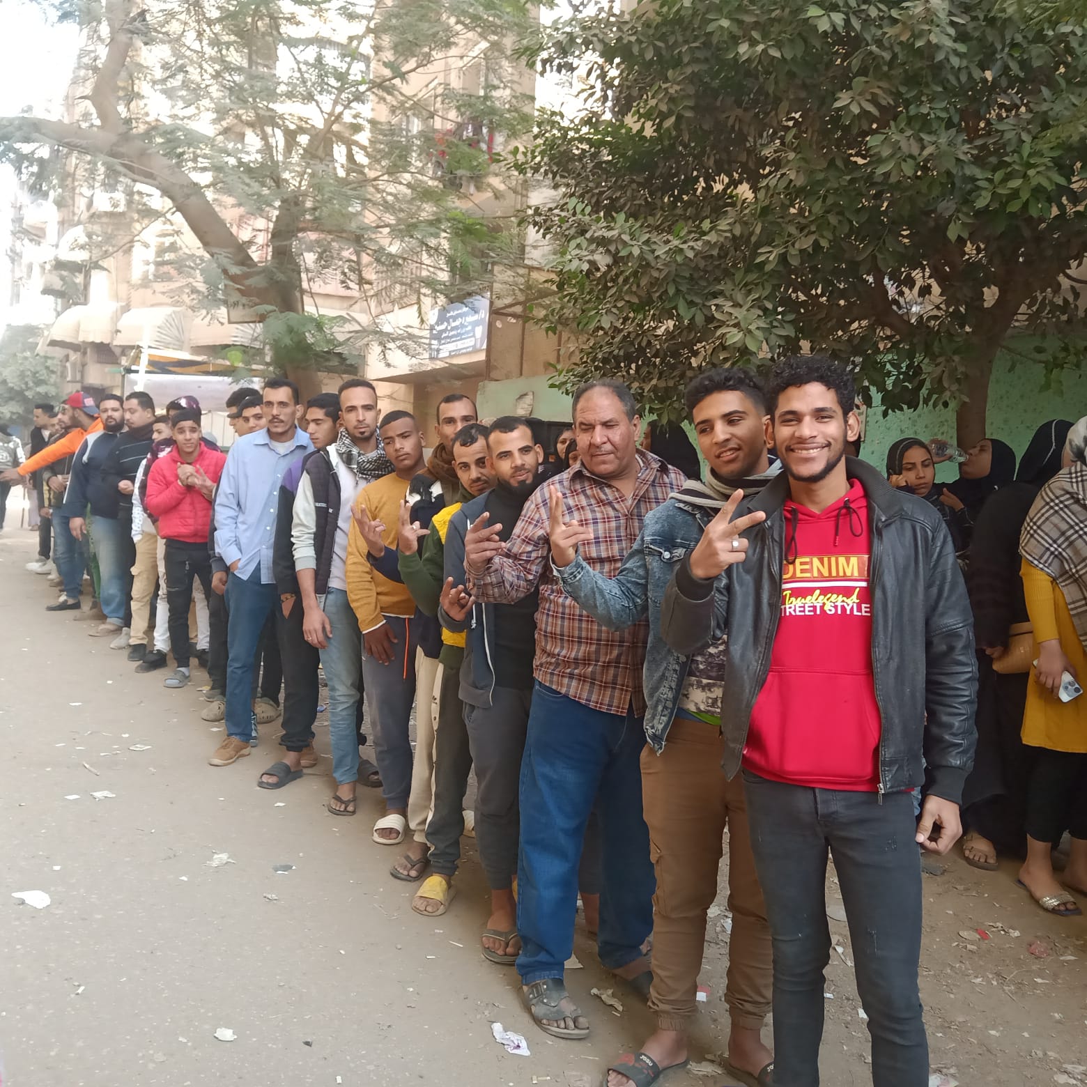 شباب يرفعون علامة النصر أمام لجان الانتخابات بمصر القديمة