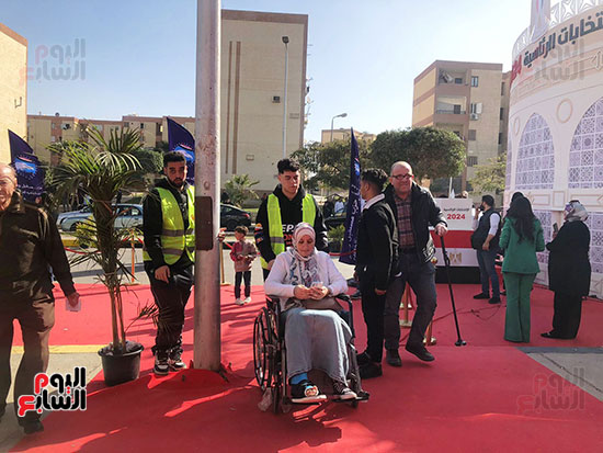 متطوعون يساعدون ذوى الهمم وكبار السن فى الوصول للجانهم الانتخابية (7)