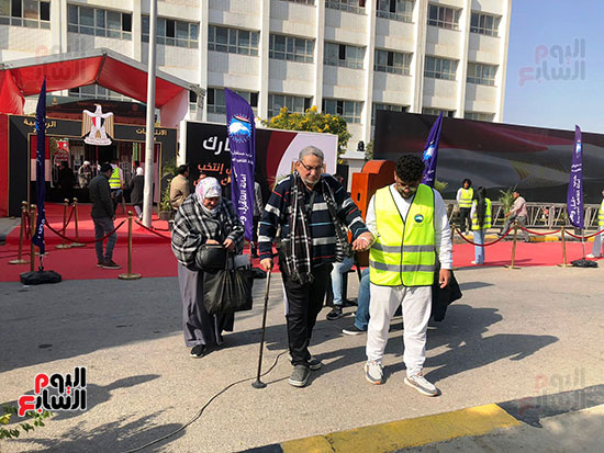 متطوعون يساعدون ذوى الهمم وكبار السن فى الوصول للجانهم الانتخابية (2)