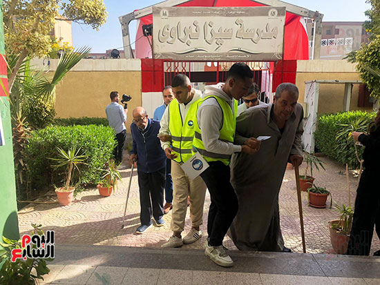 متطوعون يساعدون ذوى الهمم وكبار السن فى الوصول للجانهم الانتخابية (4)