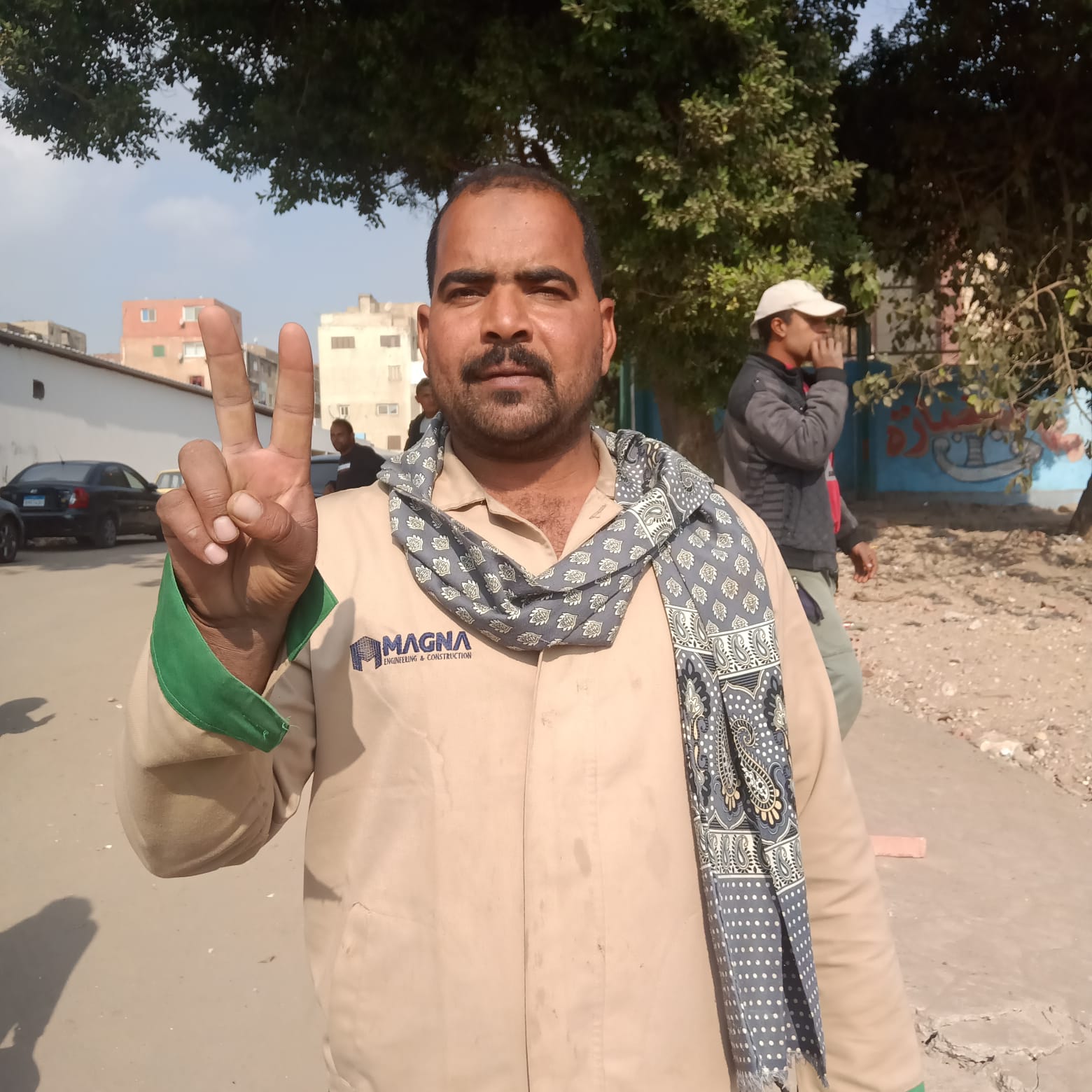 عامل يرفع علامة النصر بعد الإدلاء بصوته في الانتخابات