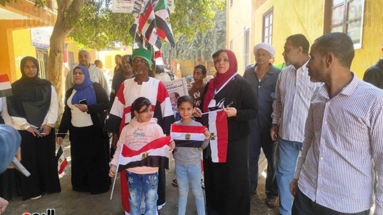 مواطن-يرتدى-علم-مصر-بالأقصر-وحوله-الأطفال-يشاركون-فى-ثالث-أيام-الانتخابات