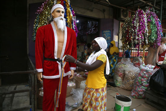 أمراه تعرض ملابس سانتا كلوز داخل اسواق عيد الميلاد فى ابيدجان