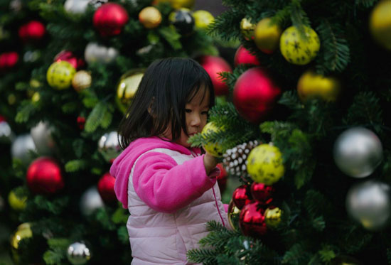 طفلة مع العاب وهدايا عيد الميلاد