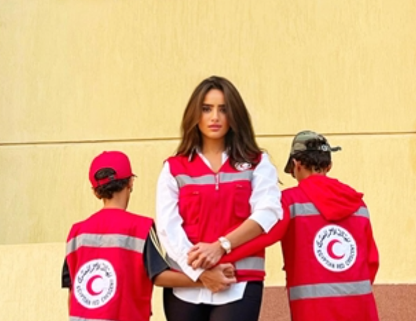 زينة ونجليها خلال صورة أثناء تطوعهم لدى الهلال الأحمر المصرى