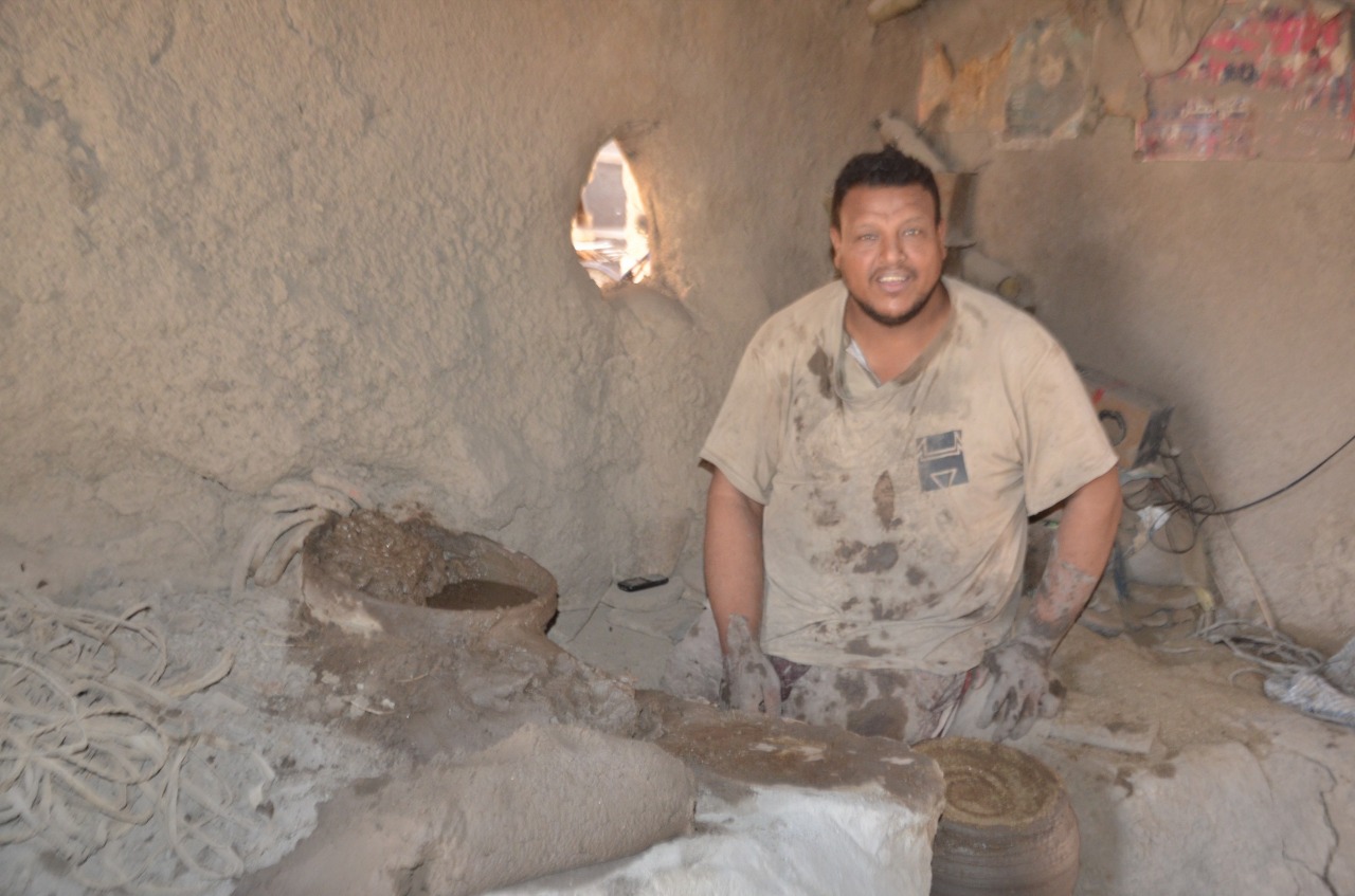 الشاب يوسف عبد العظيم خلال شرح العمل بصناعة الفخار