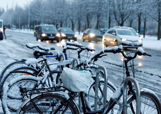 لسيارات تتخطى الدراجات المغطاة بالثلوج في فيتوريا