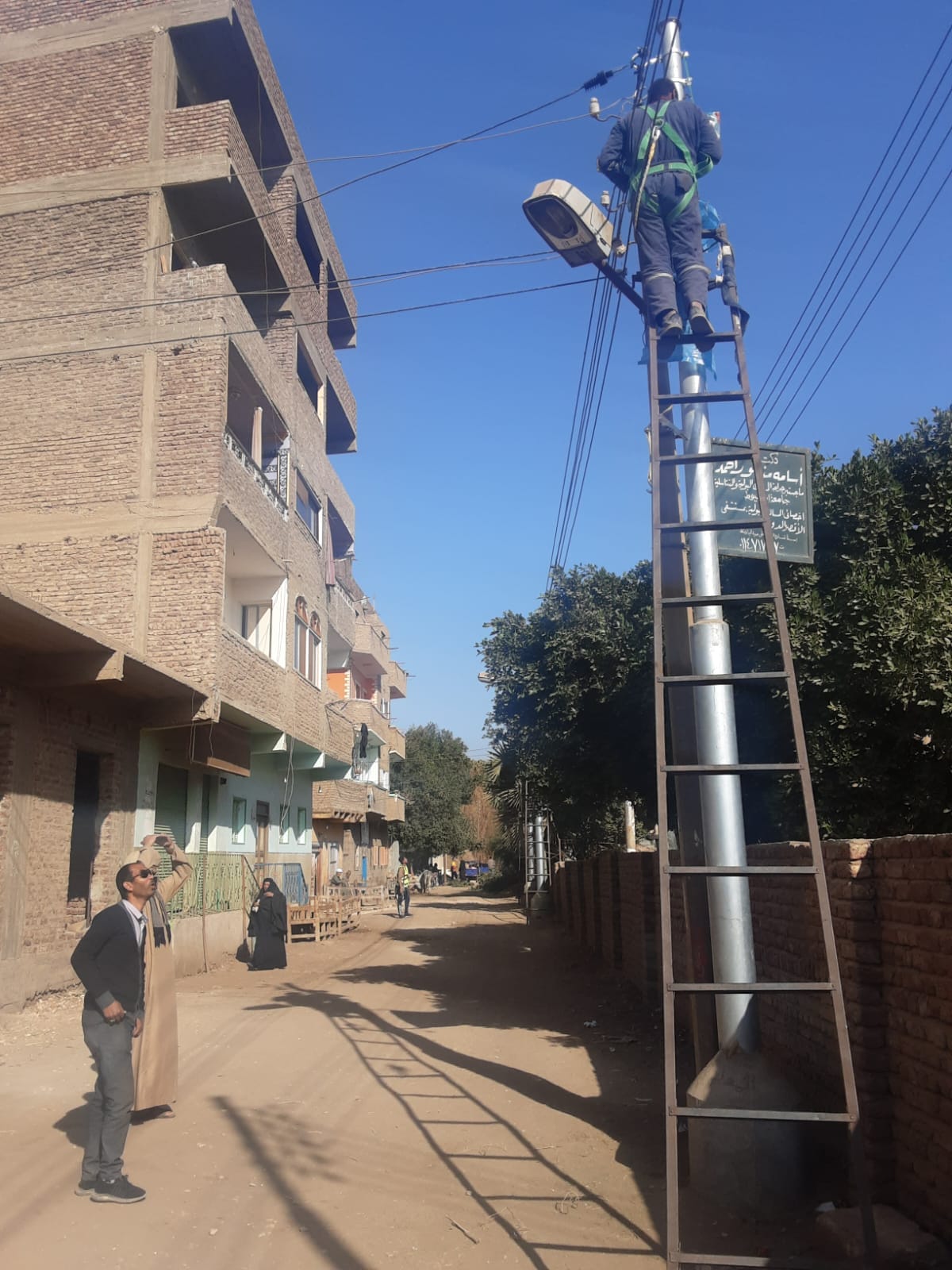 توصيل أسلاك الكهرباء بالأعمدة الجديدة فى قرية النمسا