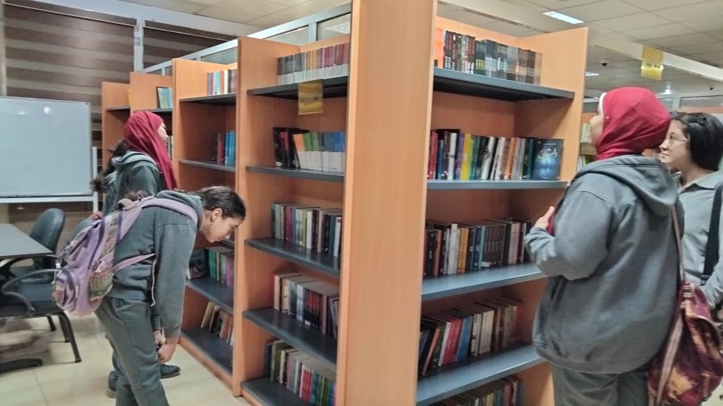 بعض الطلاب أثناء اختيار الكتب بالمكتبه