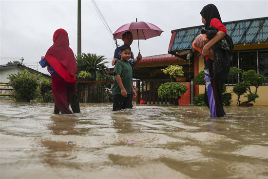 السكان-يسيرون-عبر-مياه-الفيضانات-تحت-المطر-بعد-أن-تضررت-بعض-المناطق-في-ولاية-جوهور-بالفيضانات